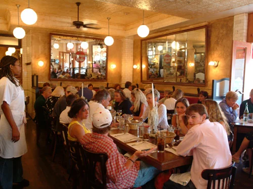Lively restaurant interior with diners enjoying meals and warm lighting