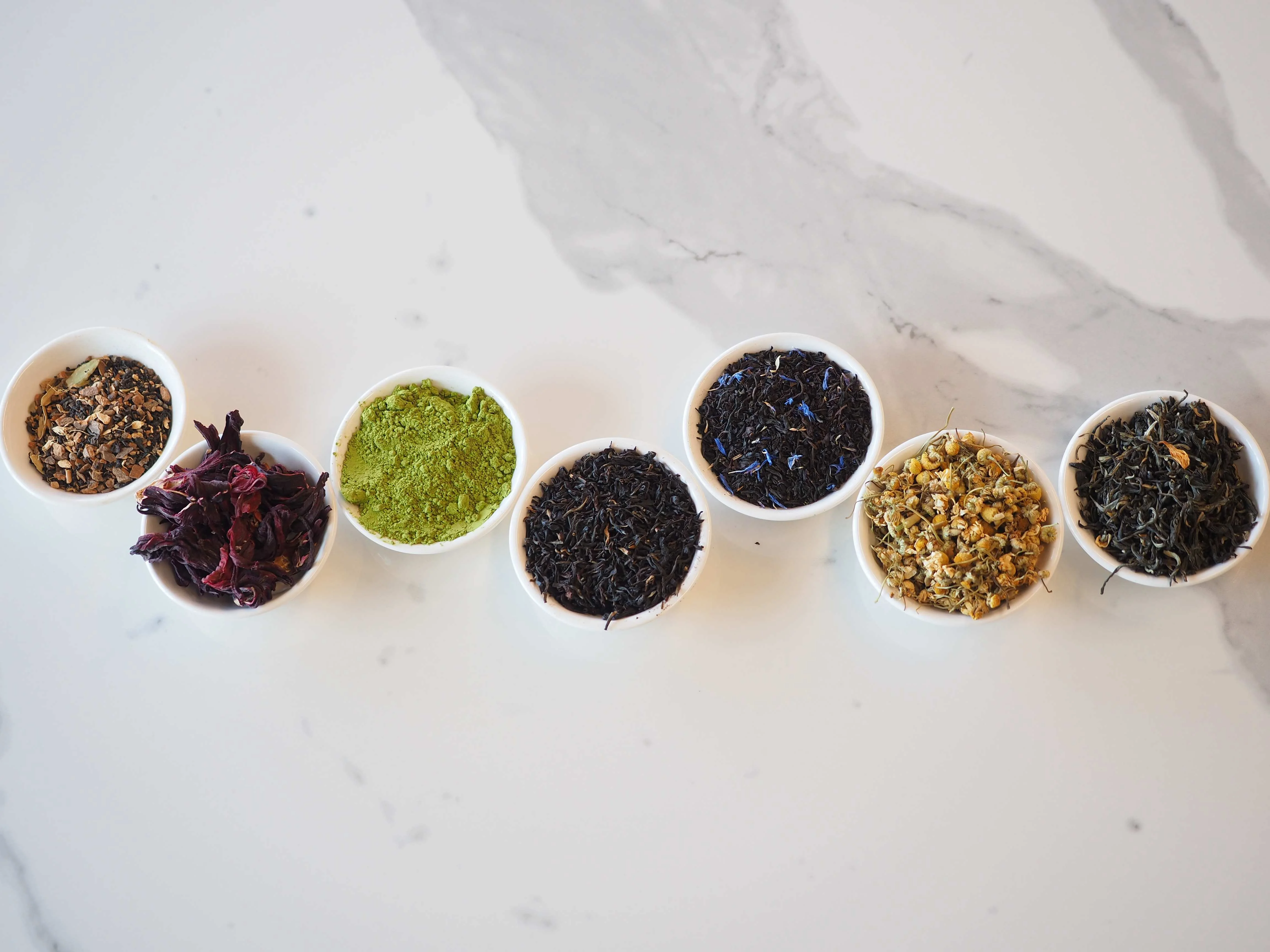 Variety of loose teas and herbs in small bowls