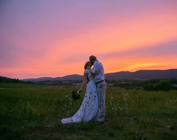 Couple embracing at sunset in a scenic field