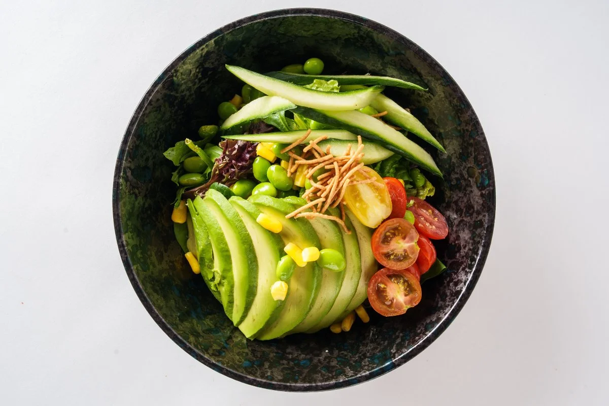 Fresh avocado salad with mixed greens and colorful vegetables