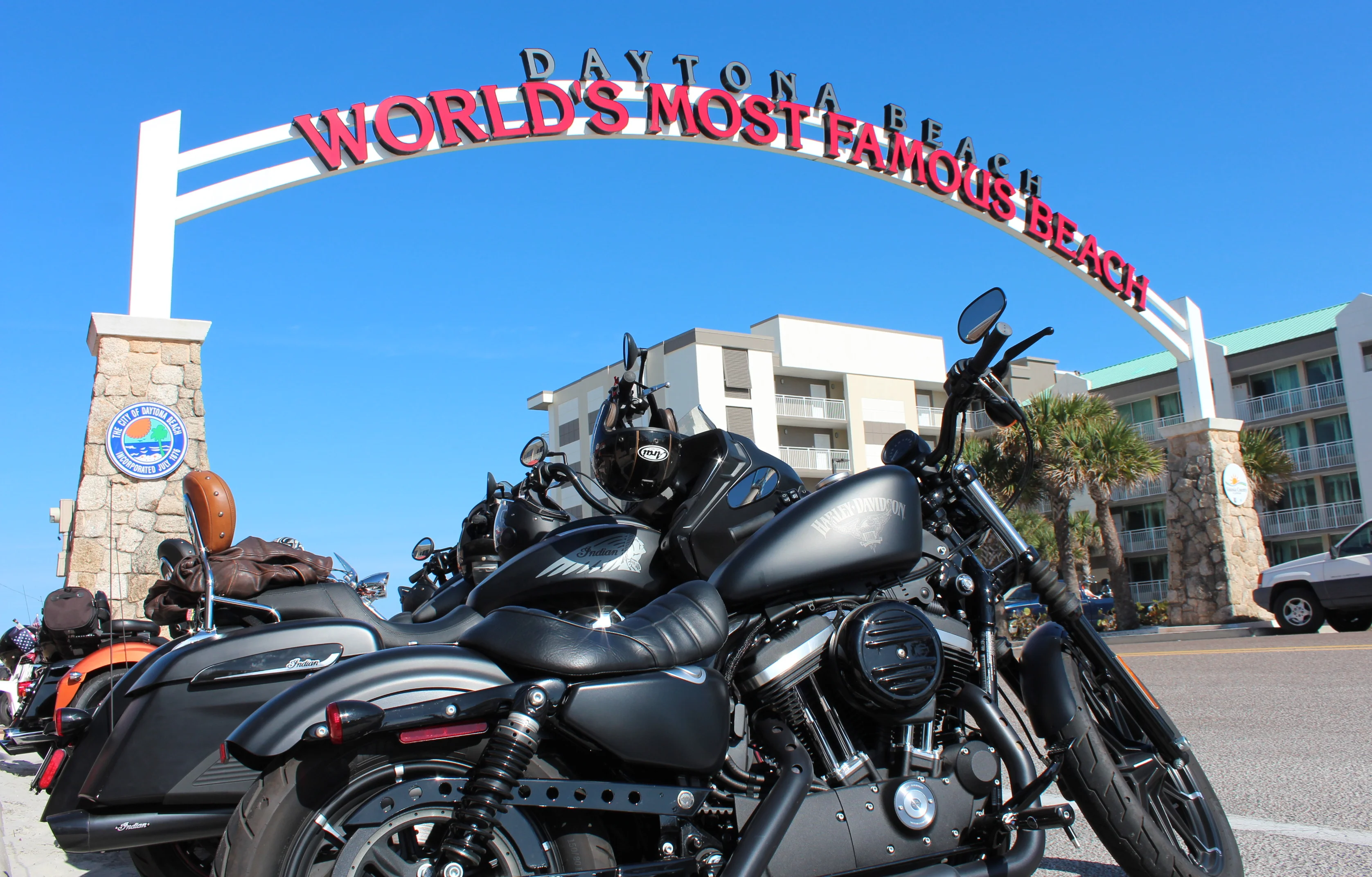Motorcycles parked at Daytona Beach entrance sign