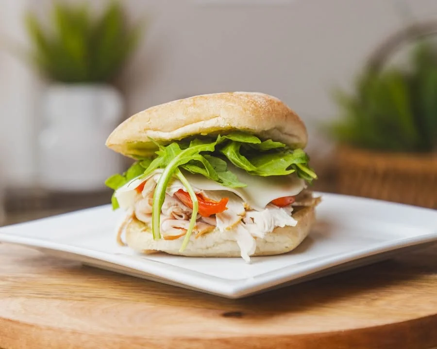 Fresh turkey sandwich with greens on a plate