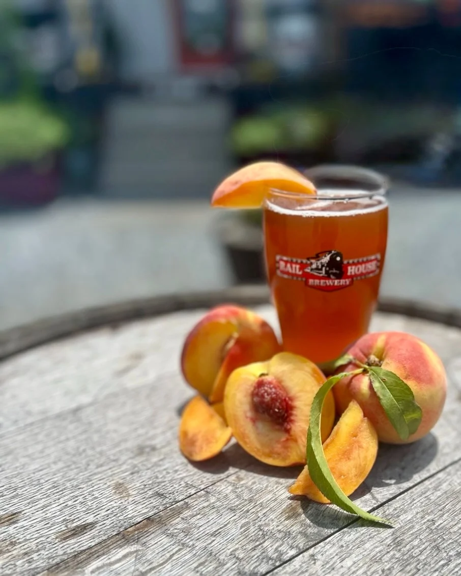 Refreshing peach beer served in a glass with fresh peaches