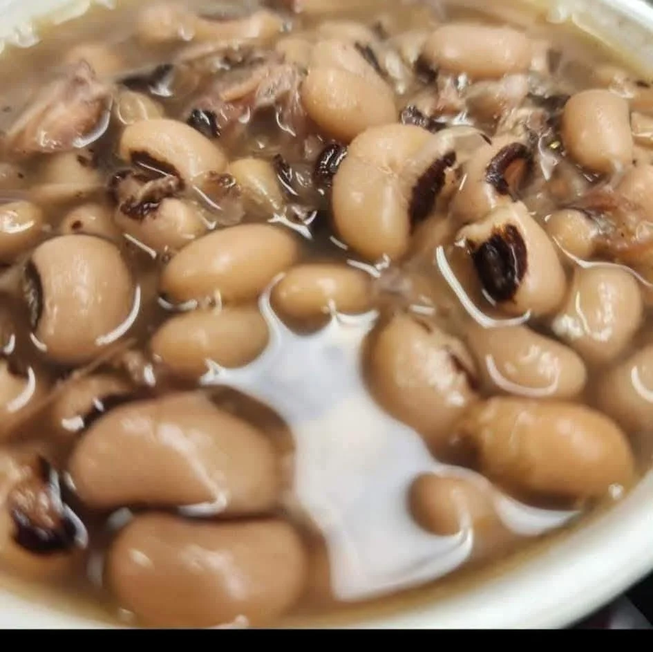 A close-up of cooked black-eyed peas in a rich broth.