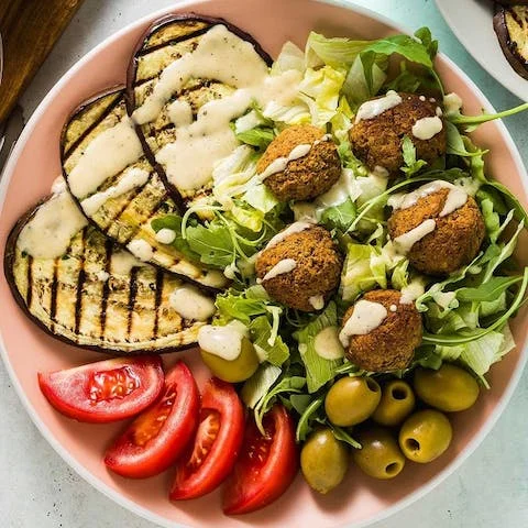 Mediterranean falafel salad with grilled eggplant and tahini dressing