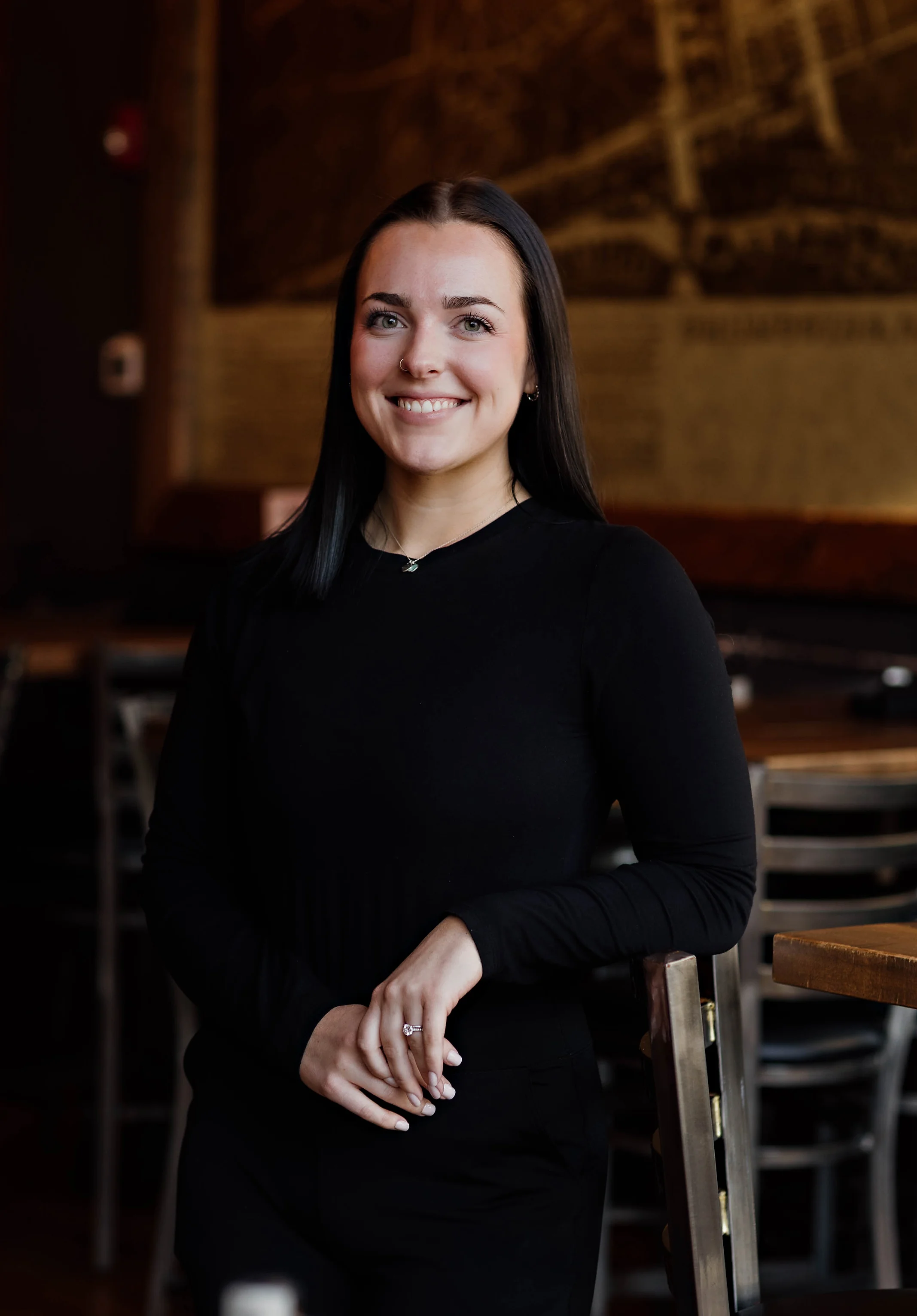 Smiling woman in a restaurant setting with warm decor