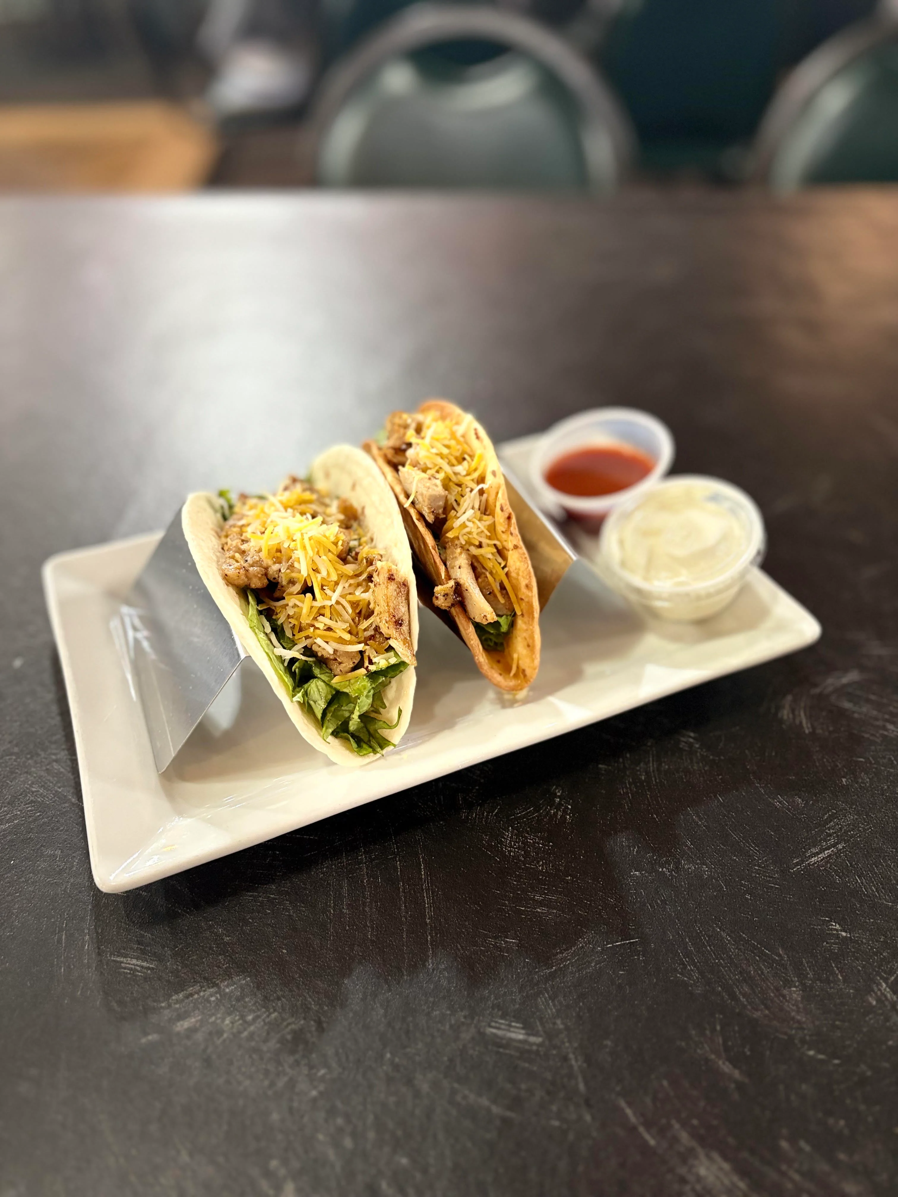 Delicious chicken tacos served with salsa and sour cream