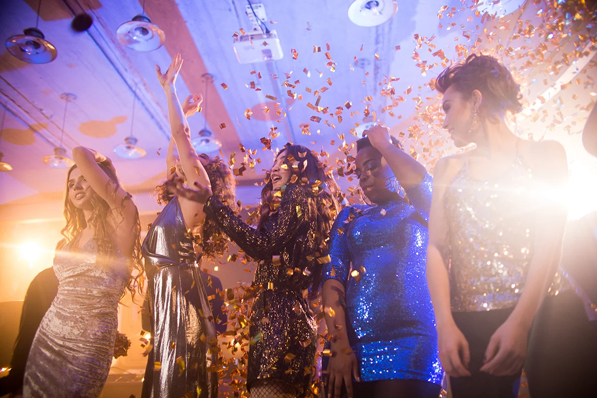 Group of friends celebrating with confetti at a party