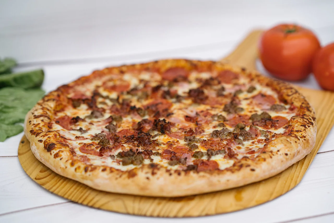 Pepperoni pizza with sausage on a wooden board