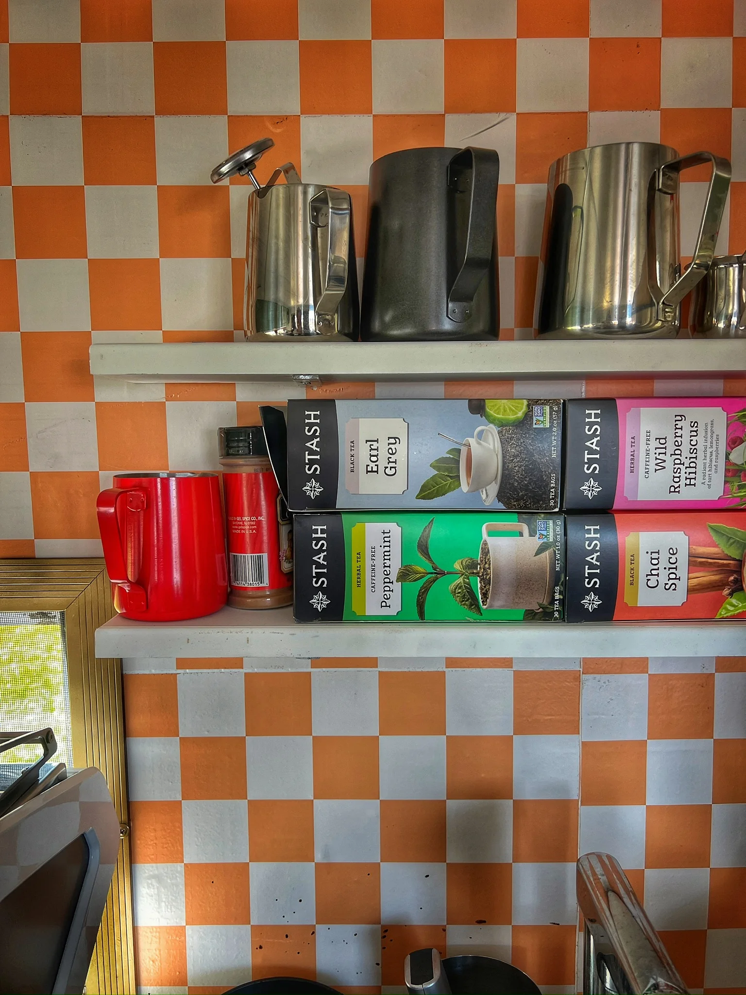 Colorful kitchen shelf with tea boxes and metal kettles