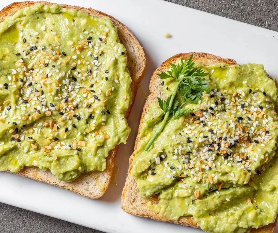 Avocado toast topped with sesame seeds and herbs