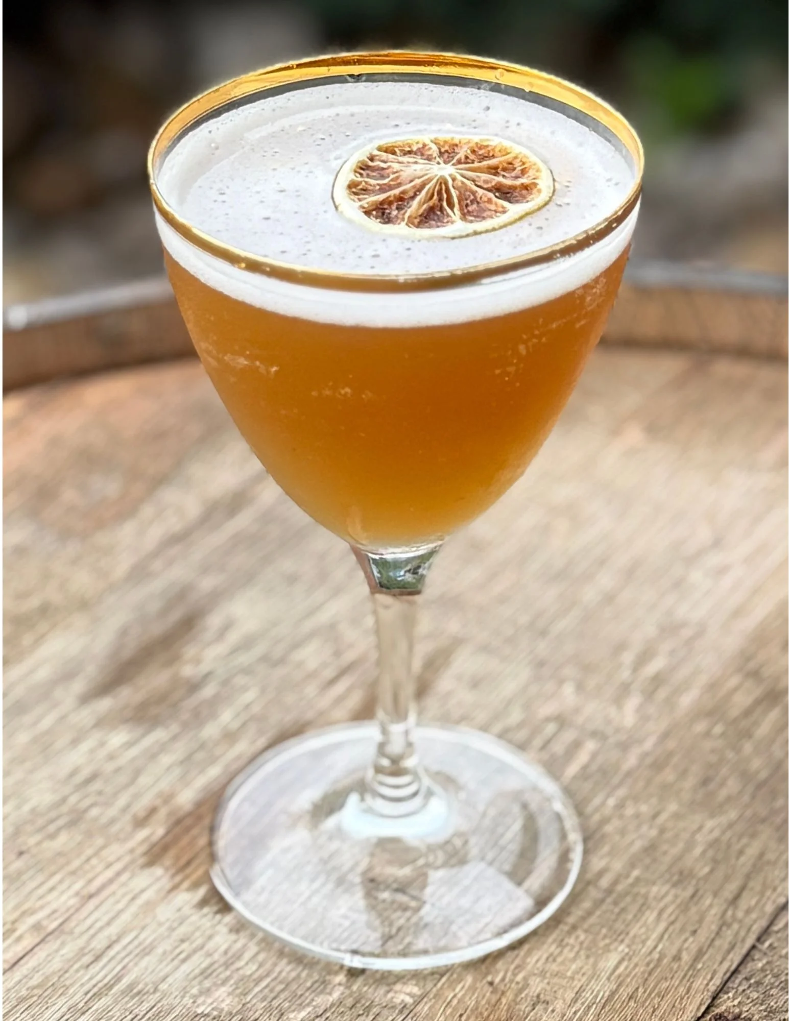 Craft cocktail with rosemary and dried orange garnish