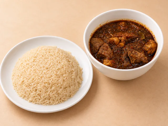 A serving of rice accompanied by a bowl of rich meat stew featuring tender pieces of meat in a flavorful sauce.