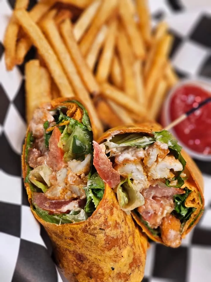 Crispy chicken wrap with fresh greens and fries