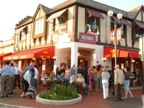 Busy restaurant exterior with patrons enjoying the evening atmosphere