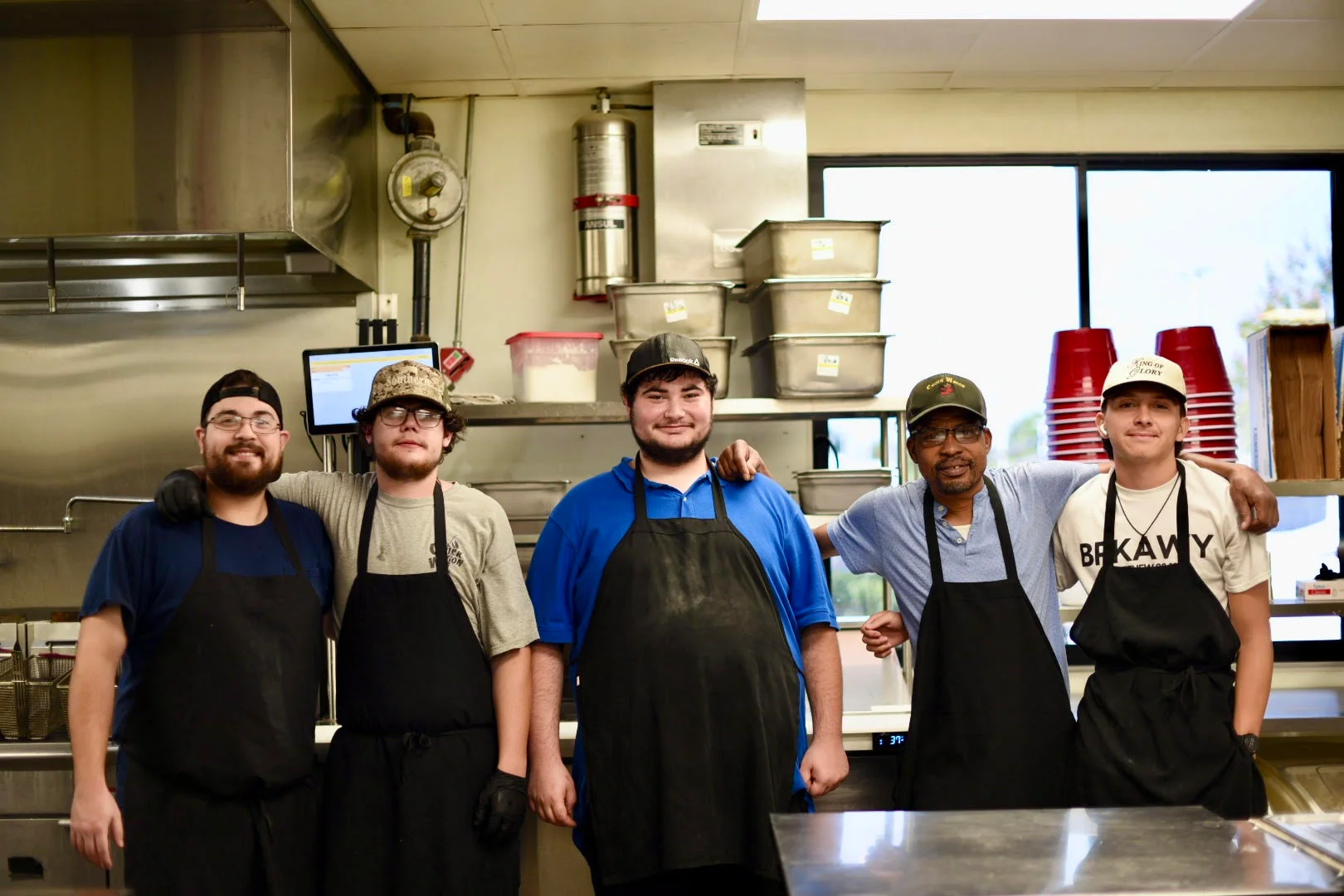 Team of chefs smiling in a restaurant kitchen