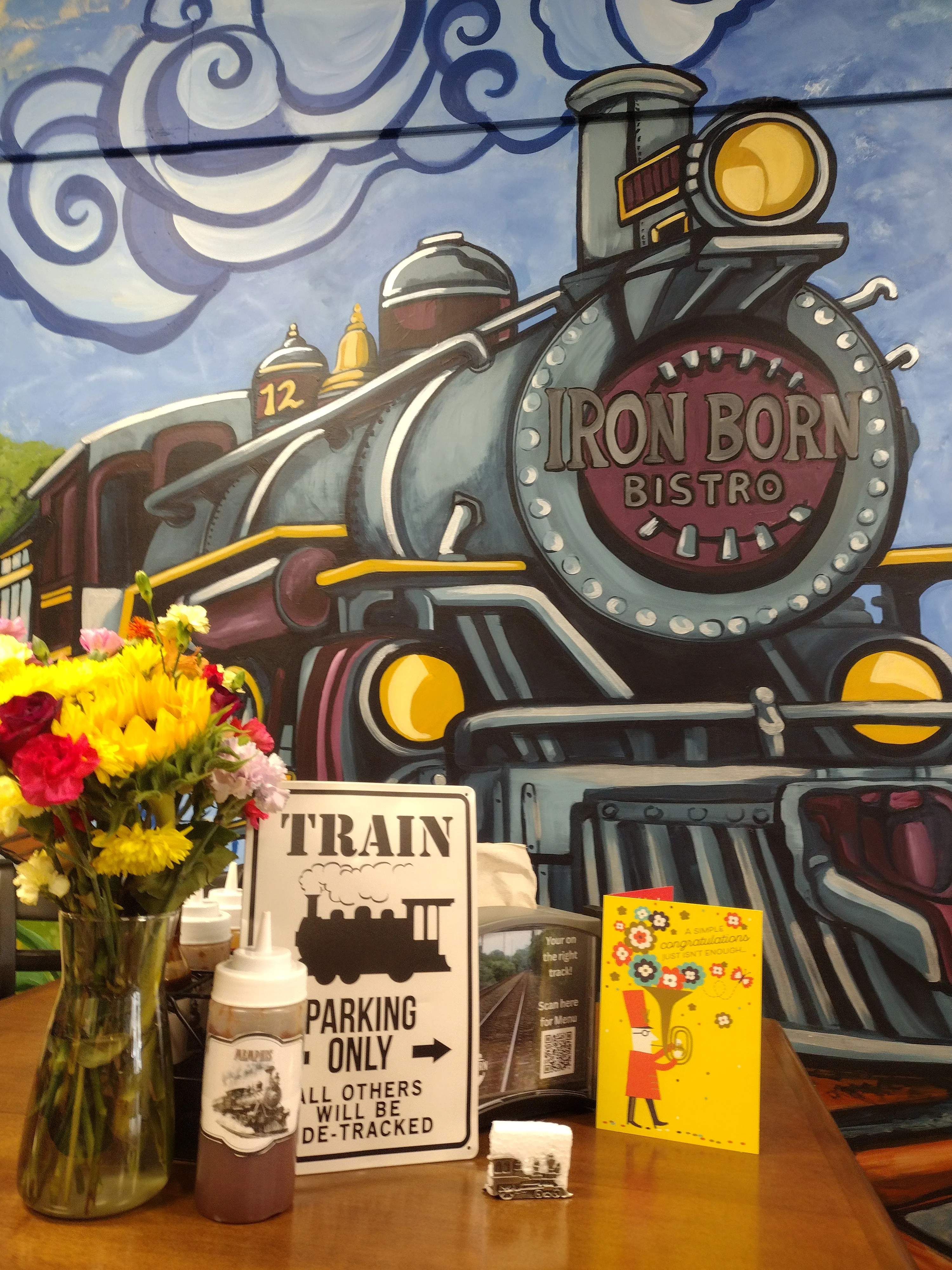 Cozy bistro interior with train mural and floral centerpiece