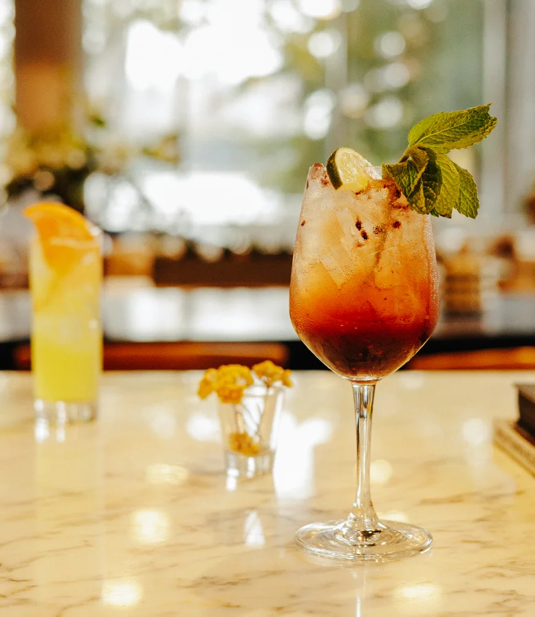Refreshing cocktail with mint and lime garnish at a stylish bar