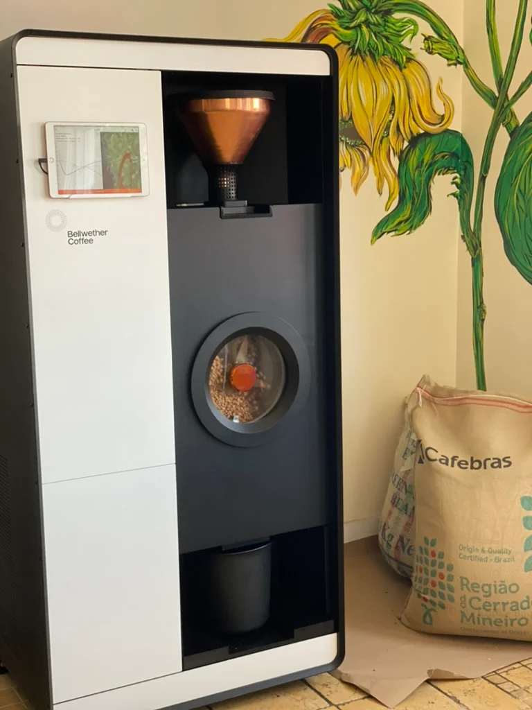 Coffee roasting machine with a digital display and coffee beans visible.