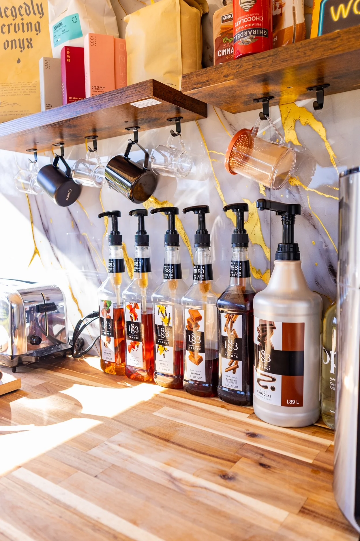 Coffee syrup station with various flavors and mugs