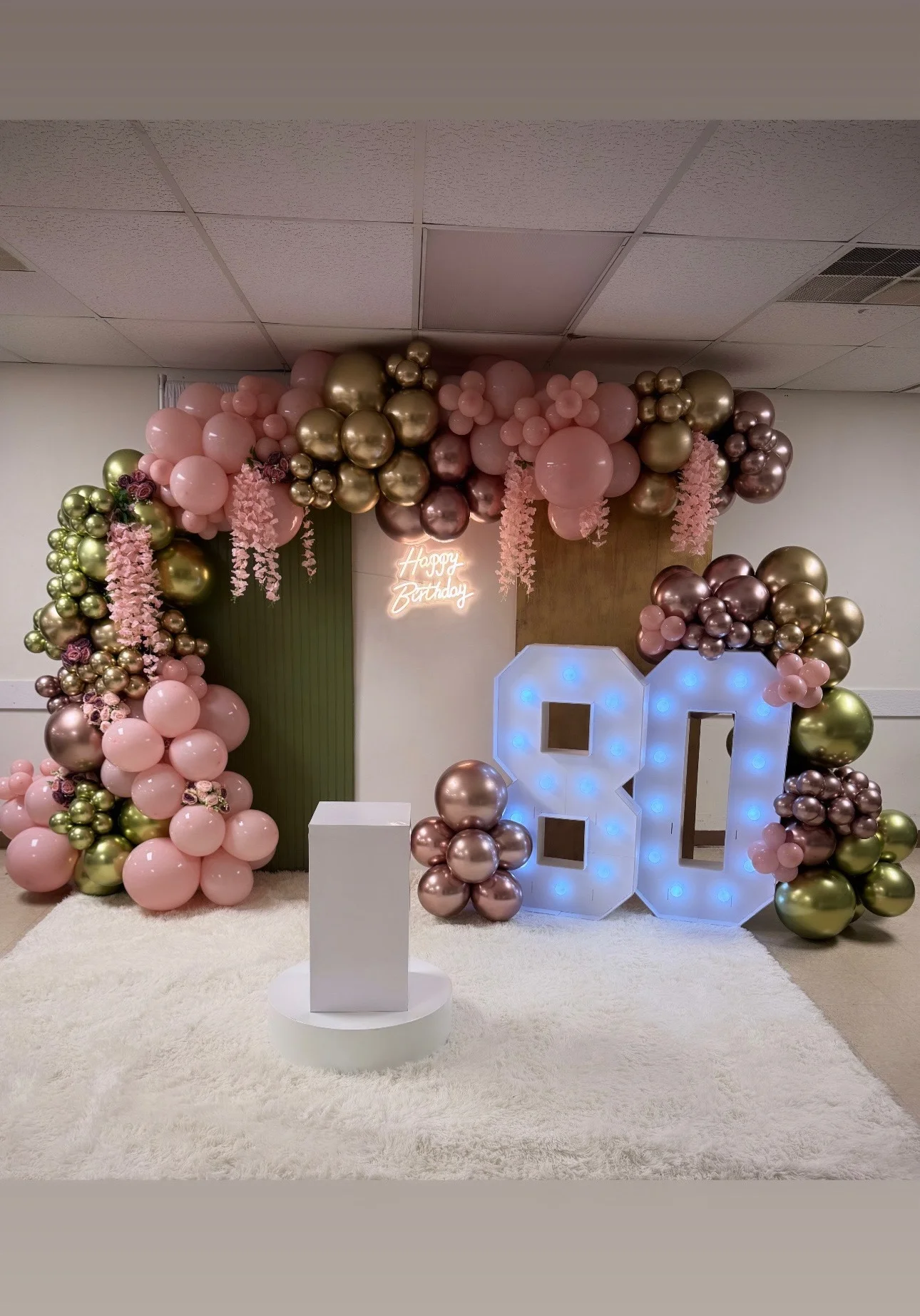 Elegant birthday backdrop with balloons and neon sign for an 80th celebration