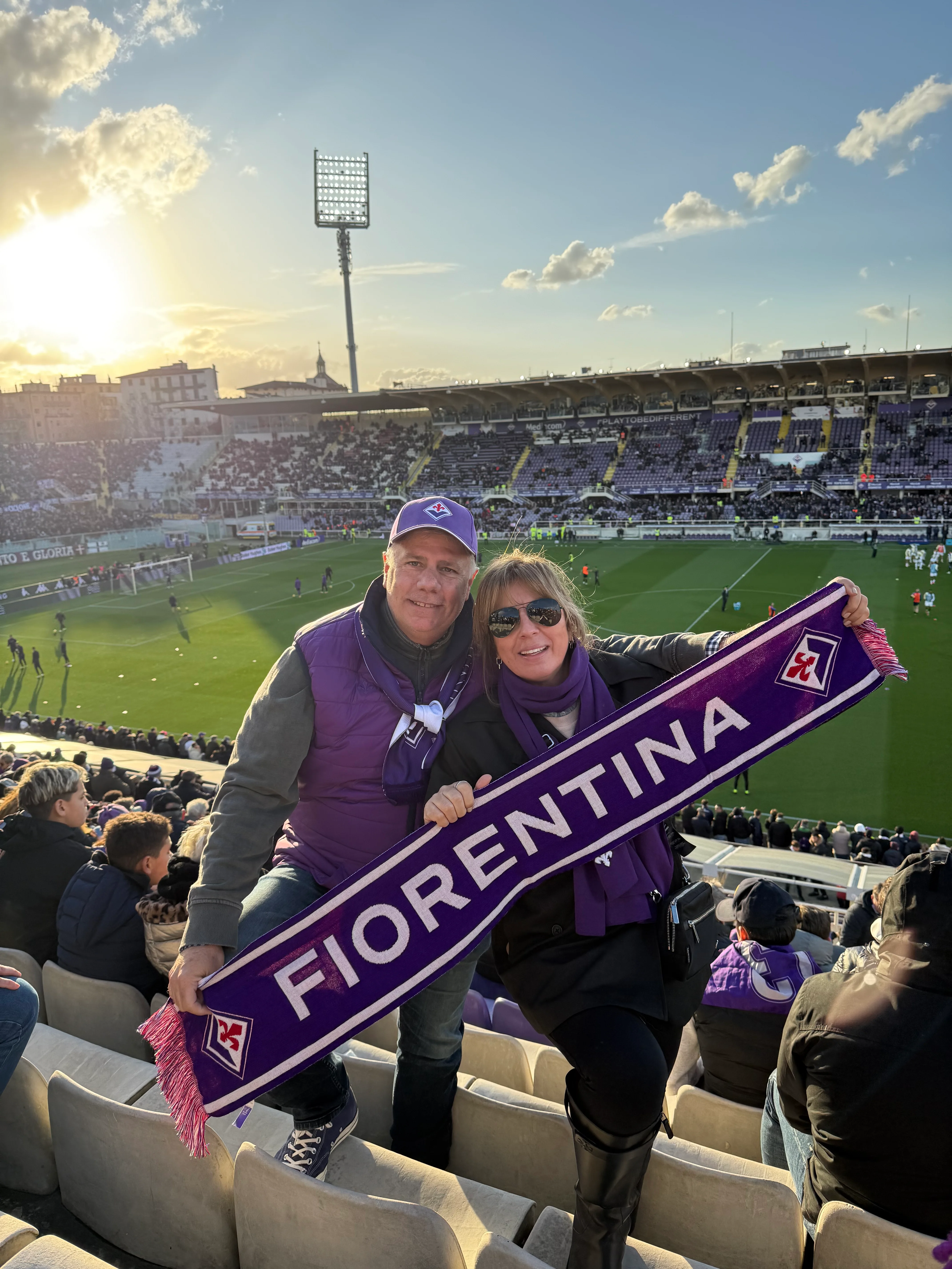 Fans cheering for Fiorentina at a soccer match in a stadium