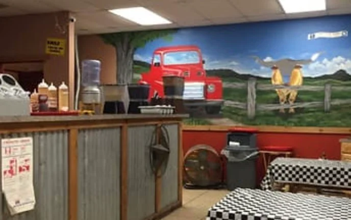 Cozy restaurant interior with rustic decor and mural of a vintage truck