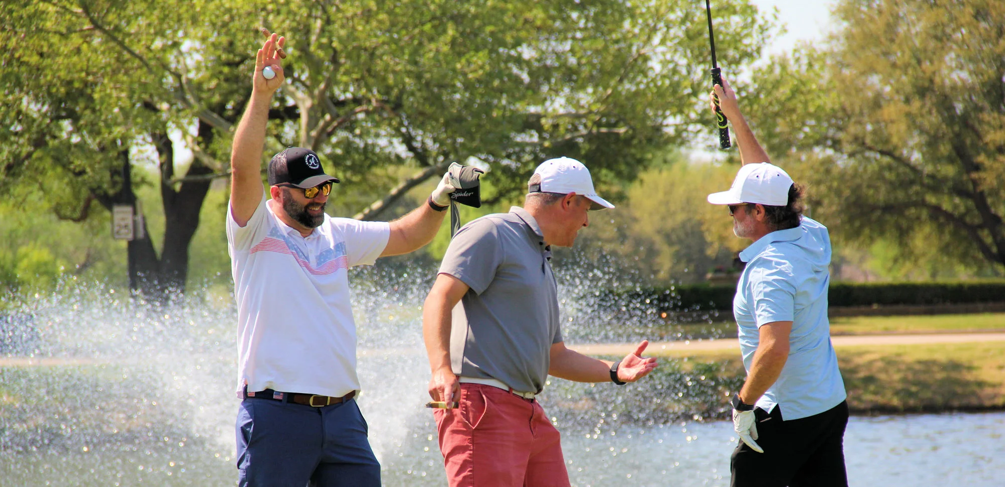 Golf tournament participants celebrating beside a scenic fountain