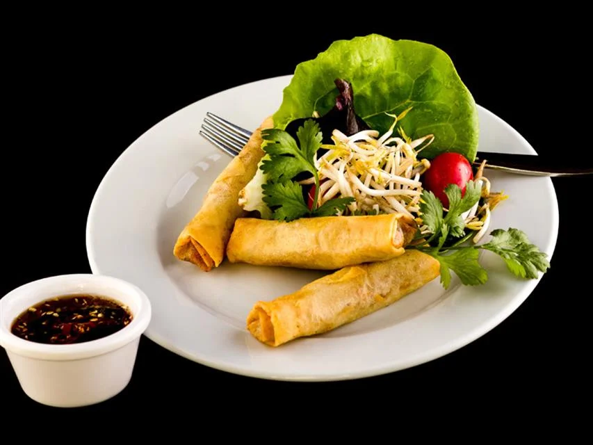 Crispy Vietnamese spring rolls with fresh herbs and dipping sauce