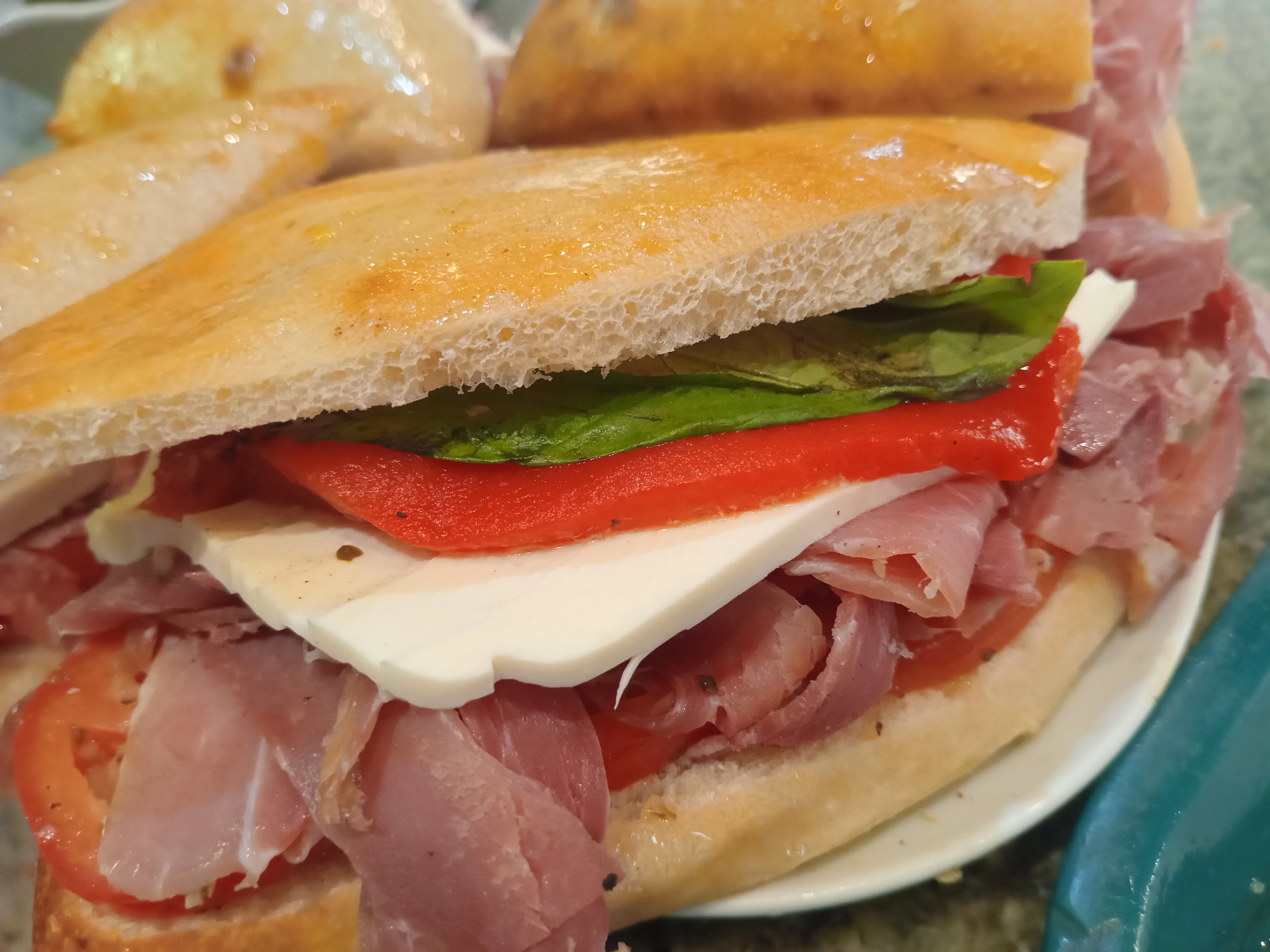 Italian panini sandwich with cured meats and fresh vegetables