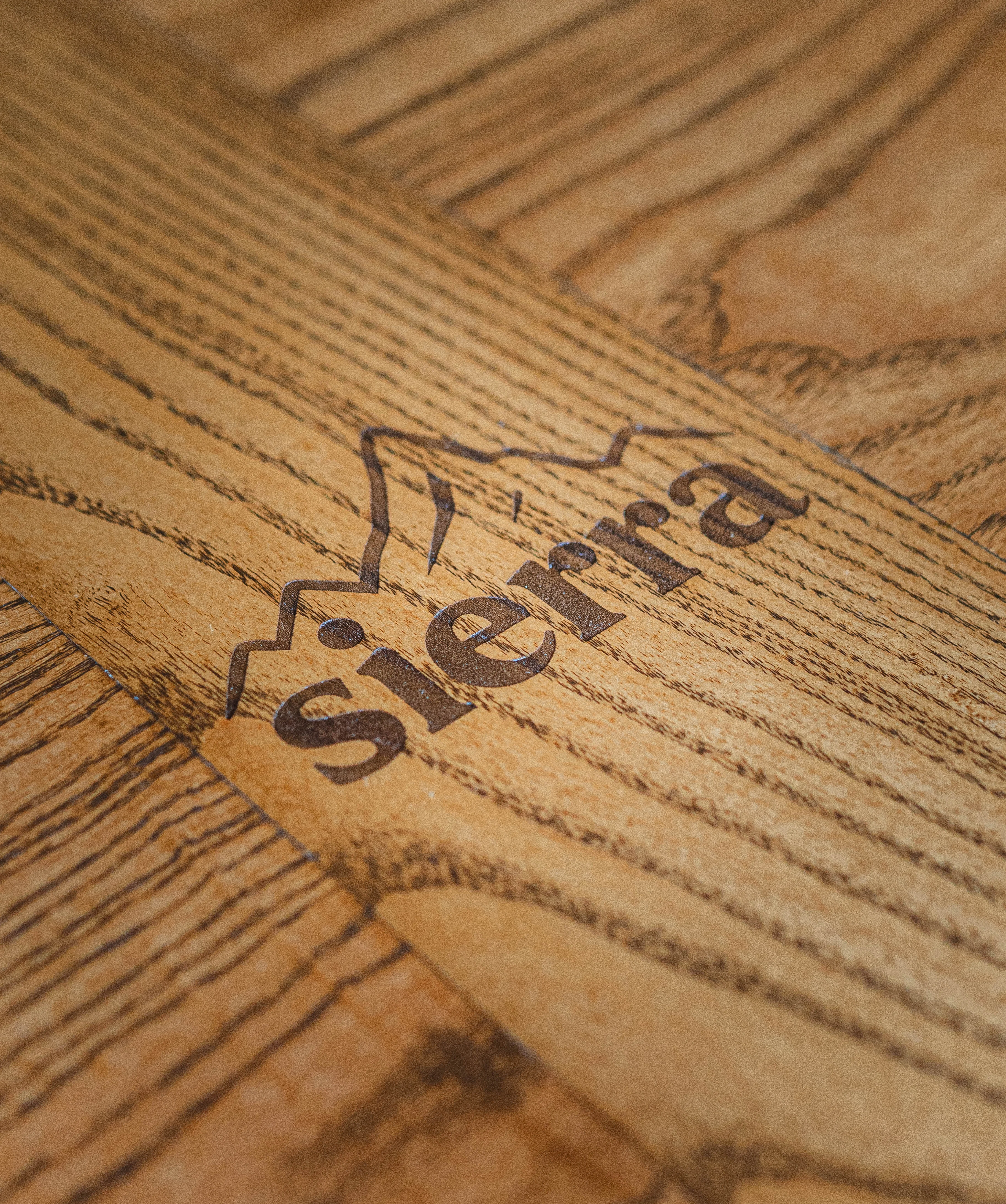 Close-up of wooden table with engraved 'Sierra' logo