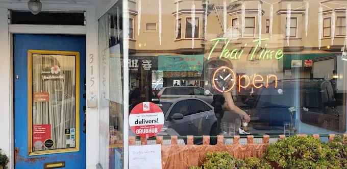 Exterior of Thai restaurant with neon 'Open' sign