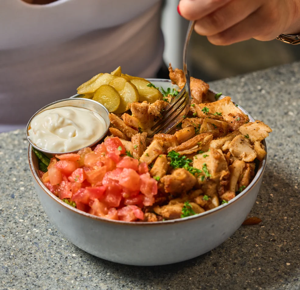 Chicken shawarma bowl with Marinated chicken served over rice with fresh toppings and garlic sauce.