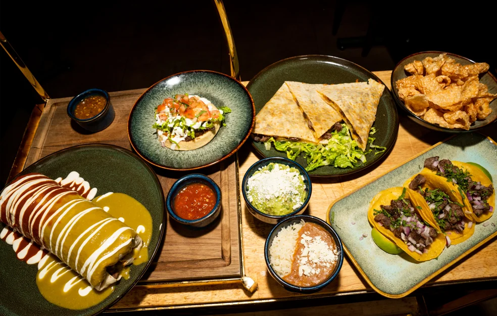 Colorful Mexican platter with tacos, enchiladas, and quesadillas