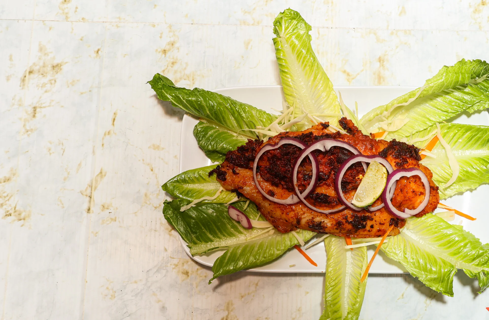 Grilled fish served on a bed of fresh lettuce