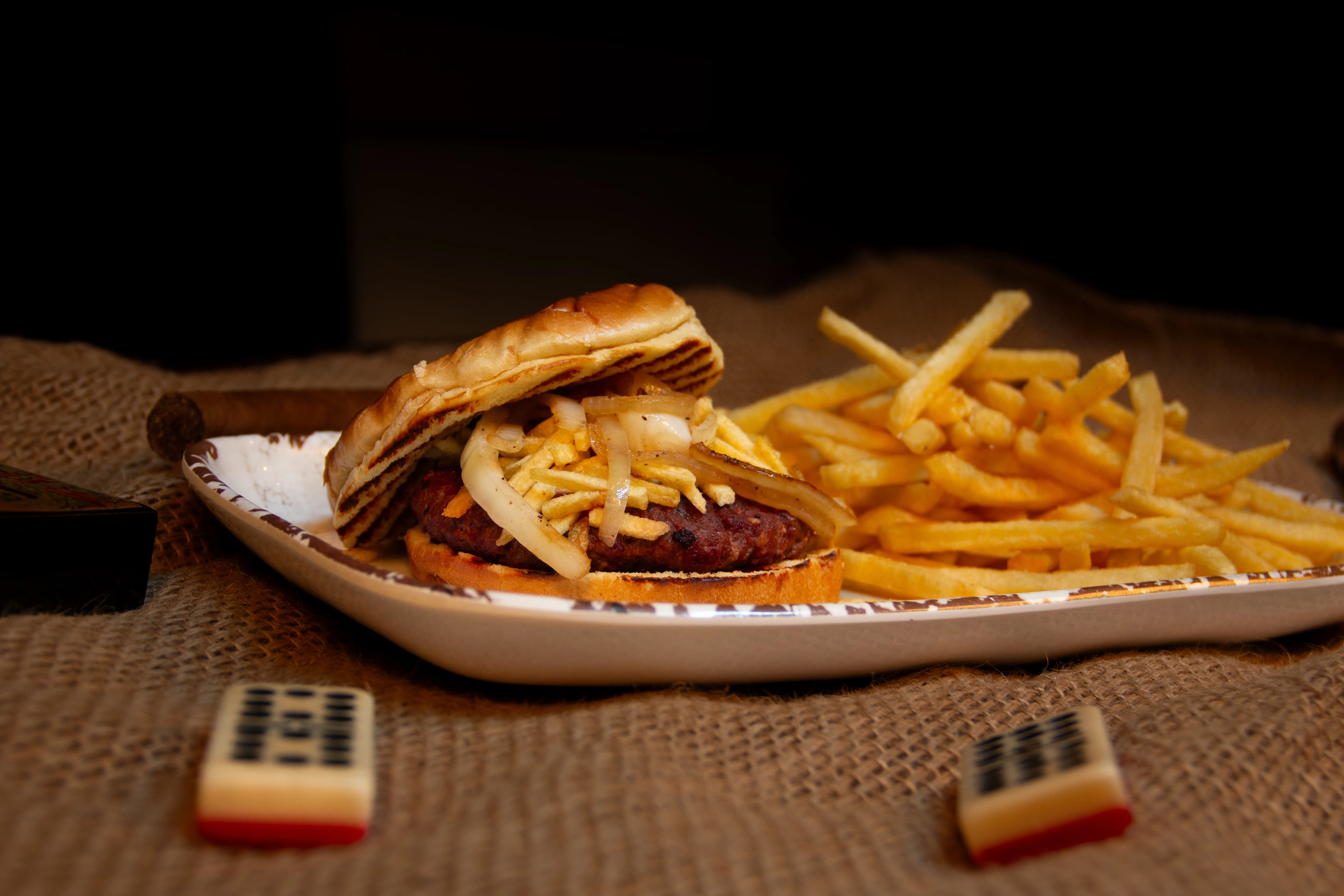 Classic American cheeseburger with fries on a rustic plate