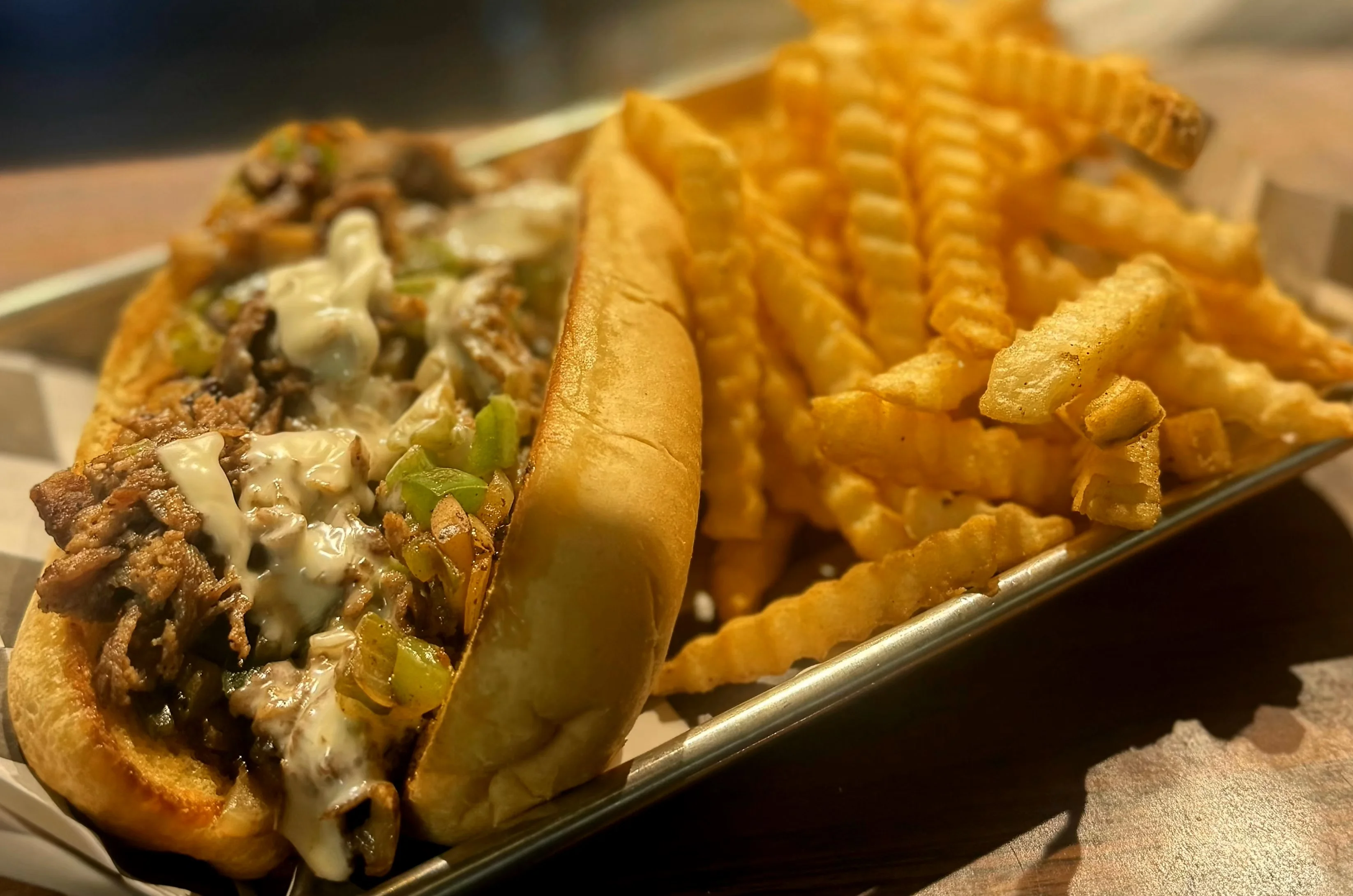 Philly cheesesteak sandwich with crinkle-cut fries
