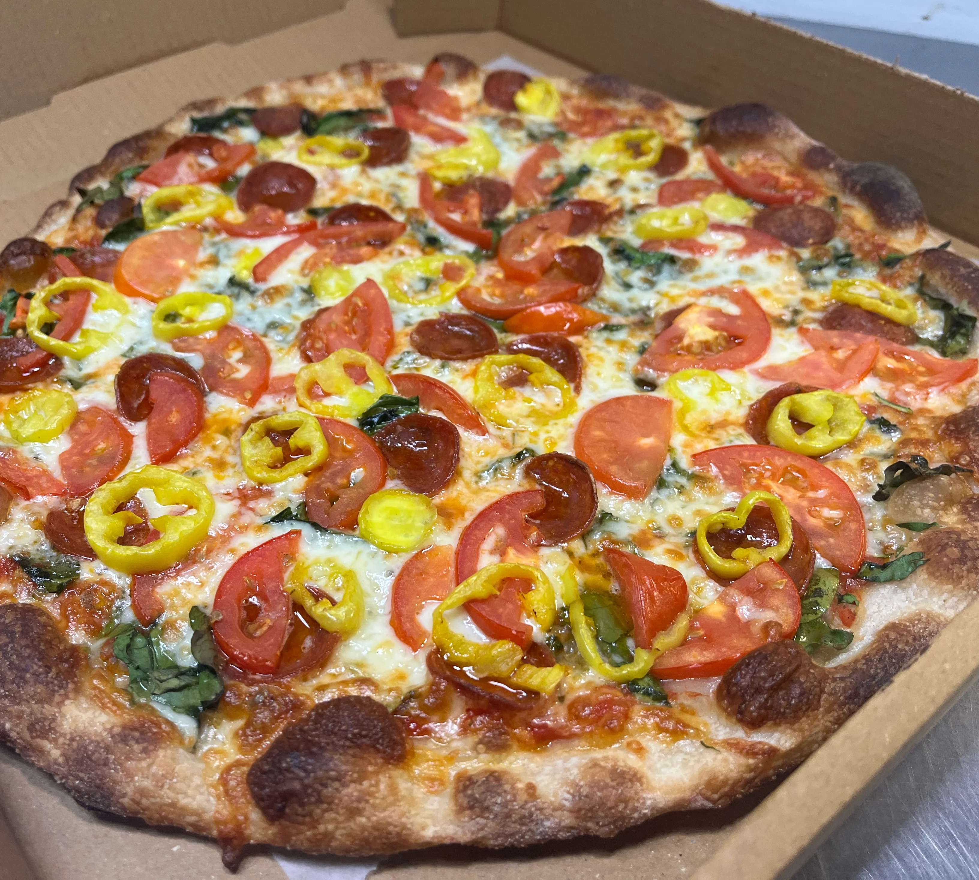Fresh pepperoni pizza with tomatoes and jalapeños