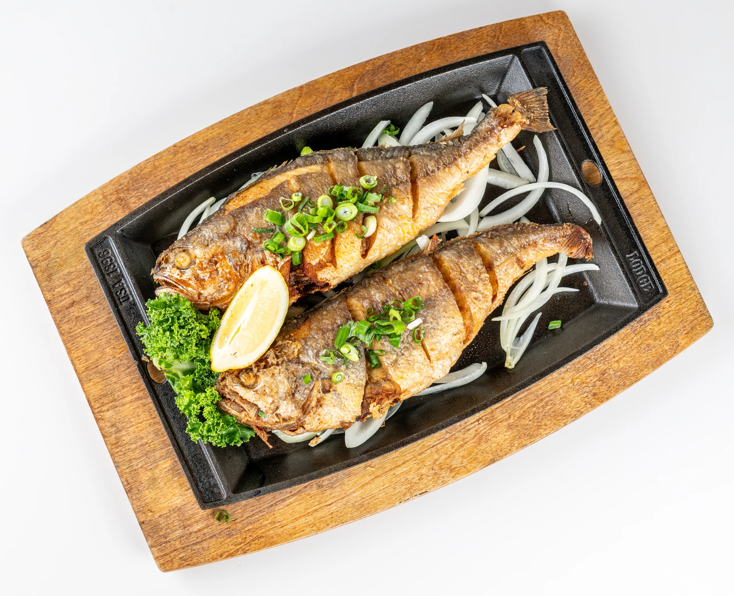Crispy fried tilapia served on a sizzling platter