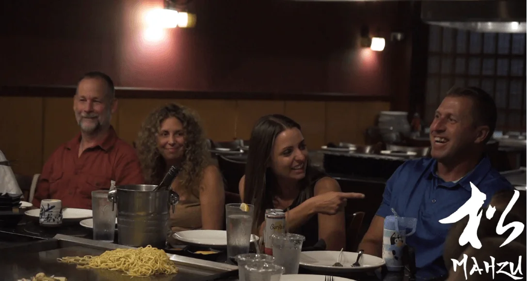 Family laughing together at a hibachi table during a rehearsal dinner at Mahzu East Windsor