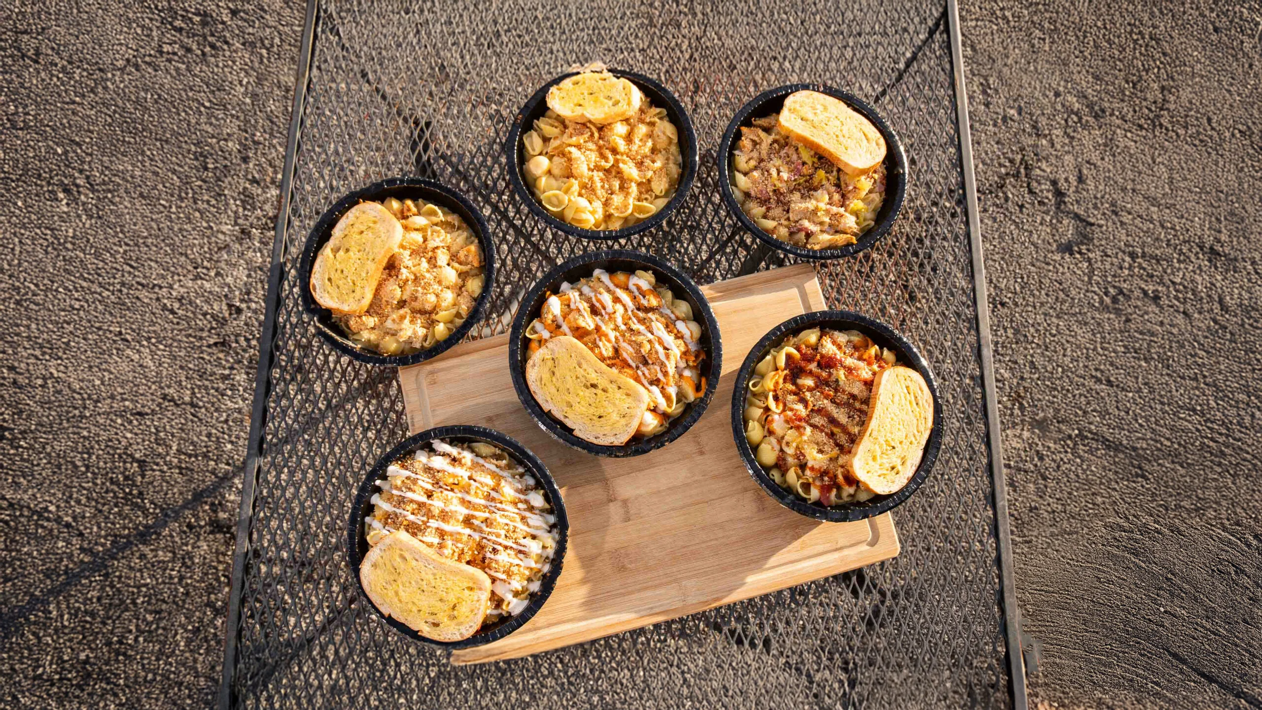 Variety of mac and cheese bowls with garlic bread