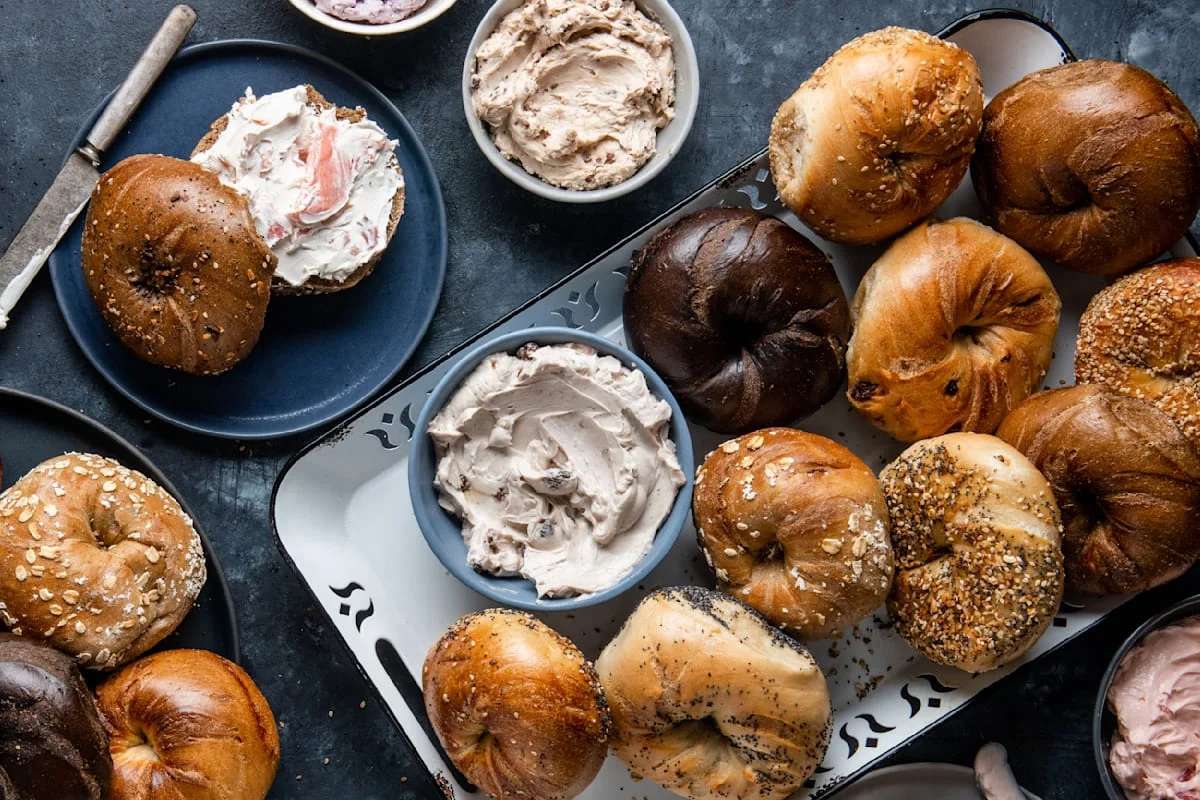 Assorted bagels with cream cheese spreads on a serving platter