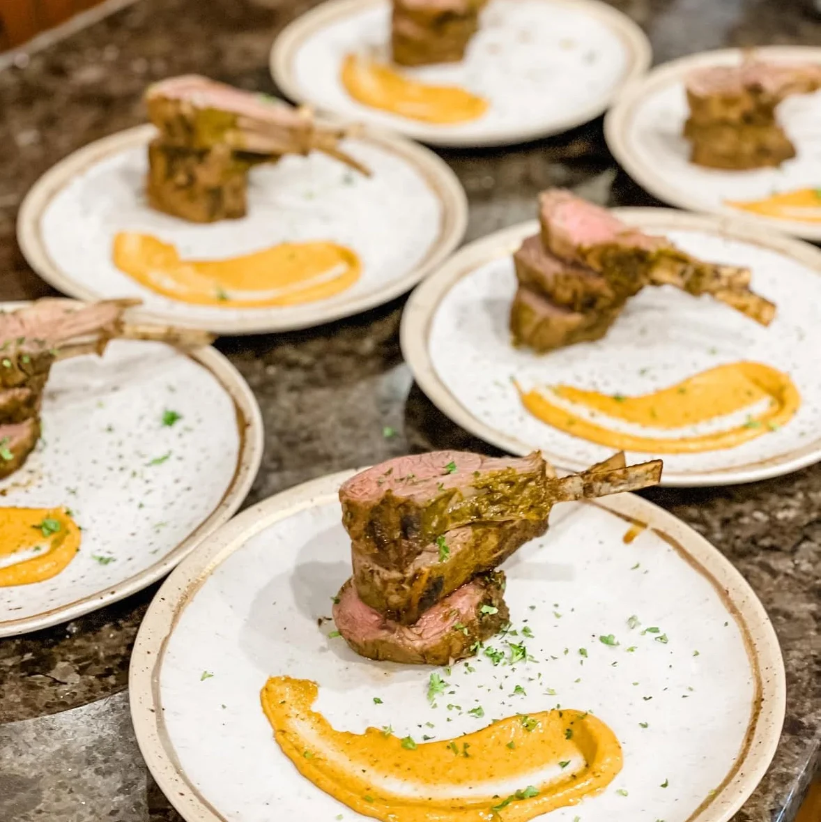 Elegant lamb chops with sauce on white plates