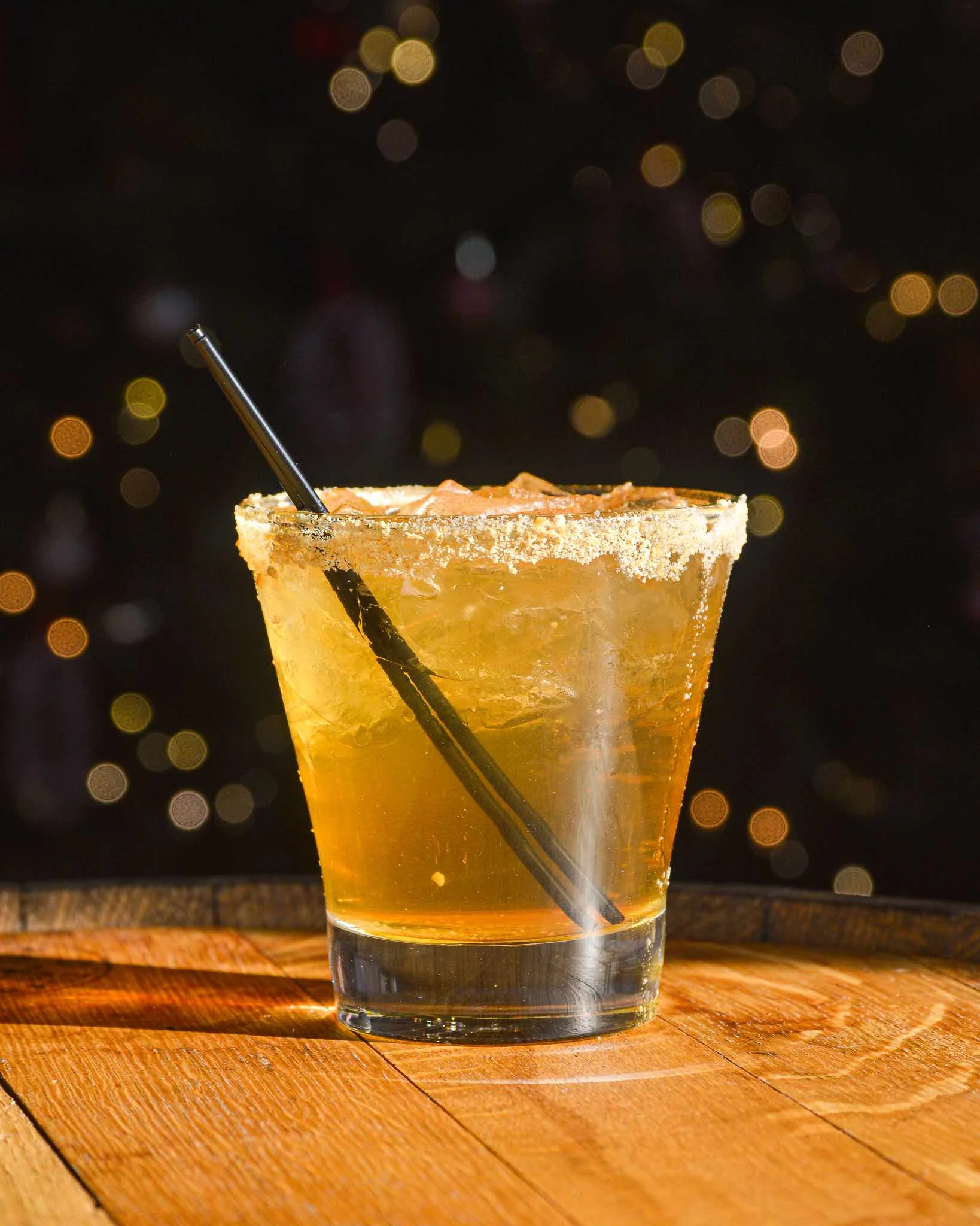 Gingerbread Man cocktail on a barrel head in front of Christmas lights