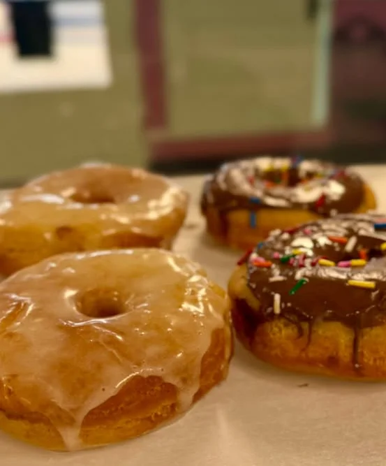 Assorted donuts with glaze and chocolate frosting topped with sprinkles
