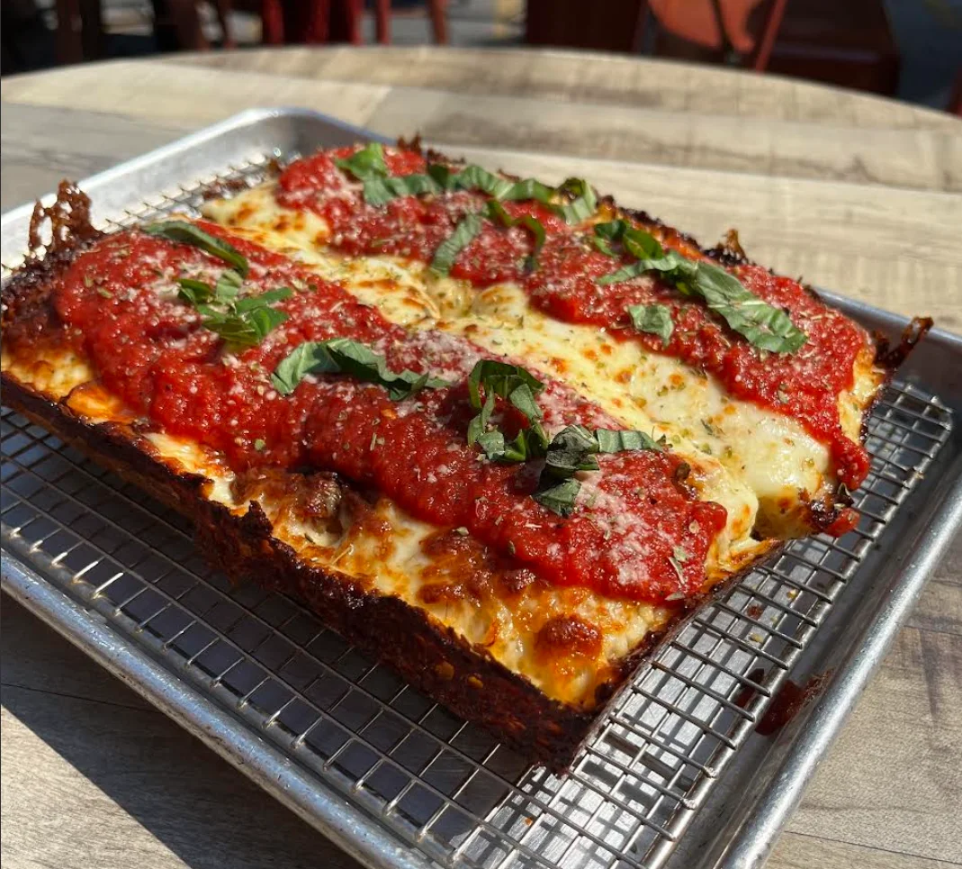 Detroit-style pizza topped with marinara and fresh basil