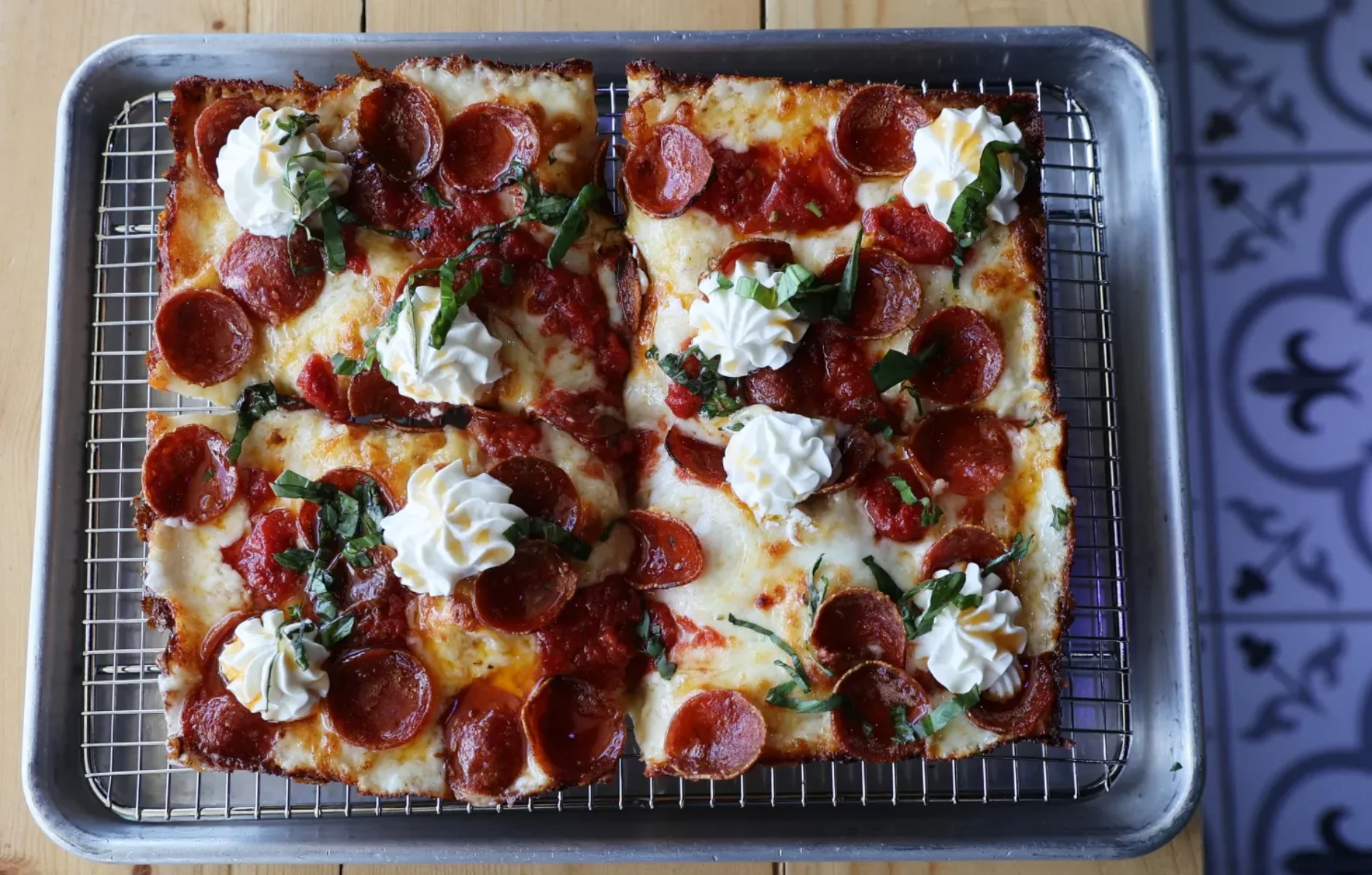Pepperoni pizza with whipped cream and basil garnish