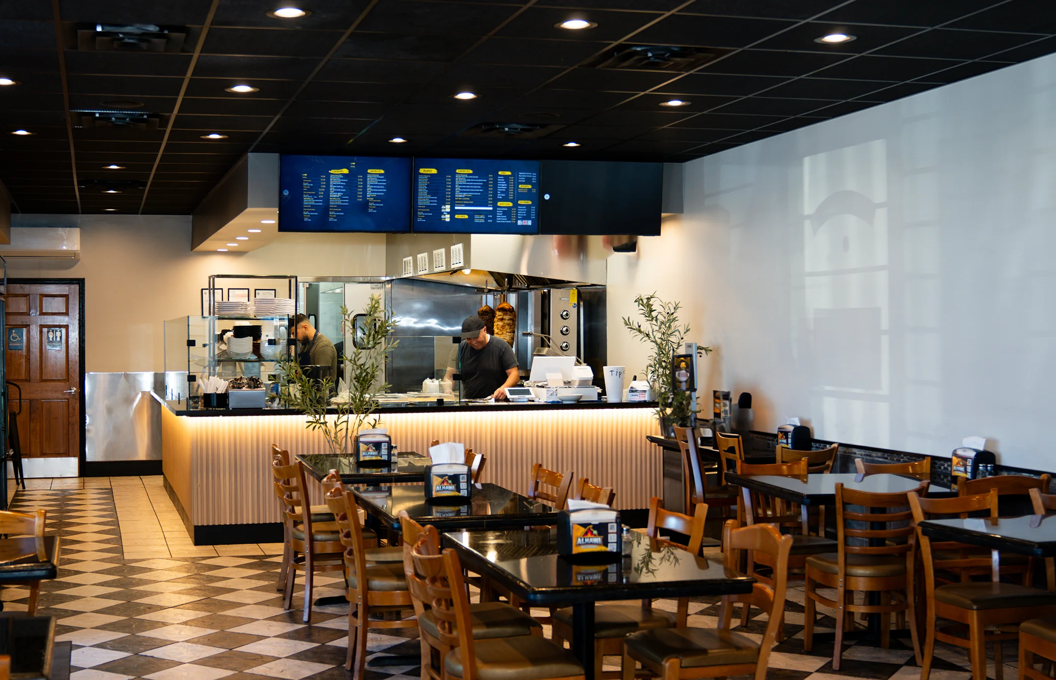 Modern restaurant interior with open kitchen and seating area