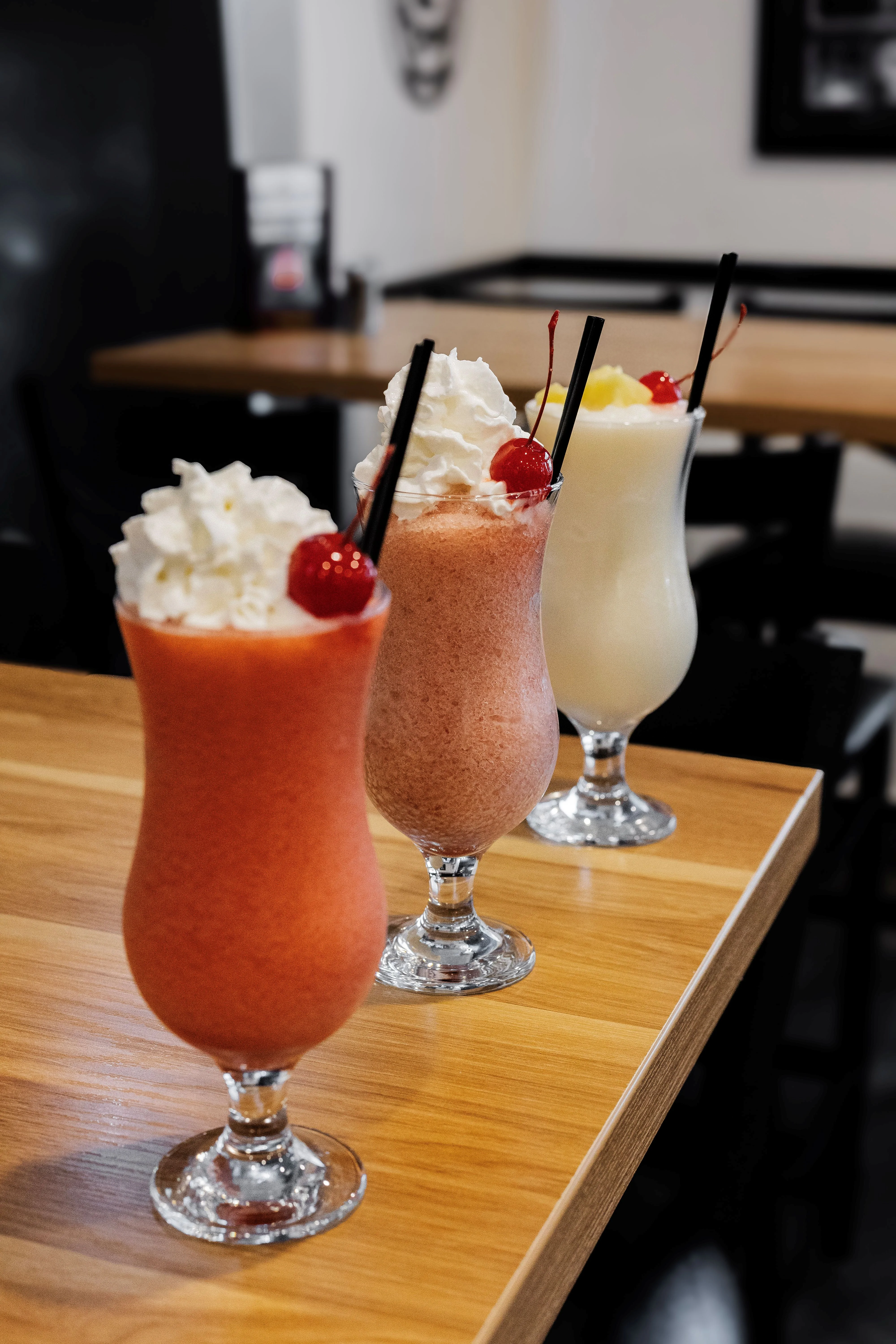 Colorful tropical cocktails with whipped cream and cherries