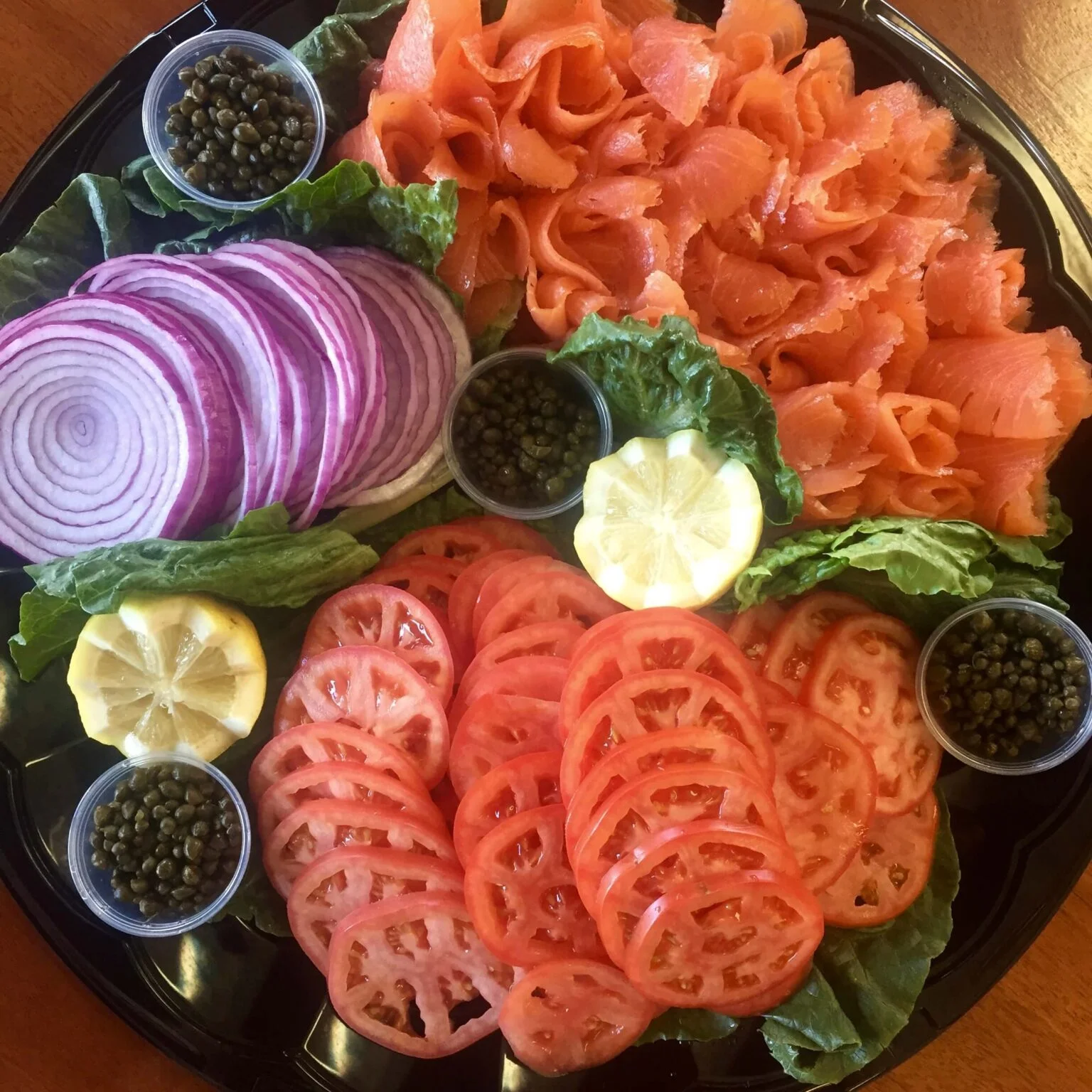 Smoked salmon platter with fresh vegetables and garnishes